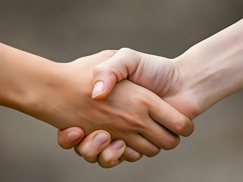 two-handshake-with-one-being-held-up-other